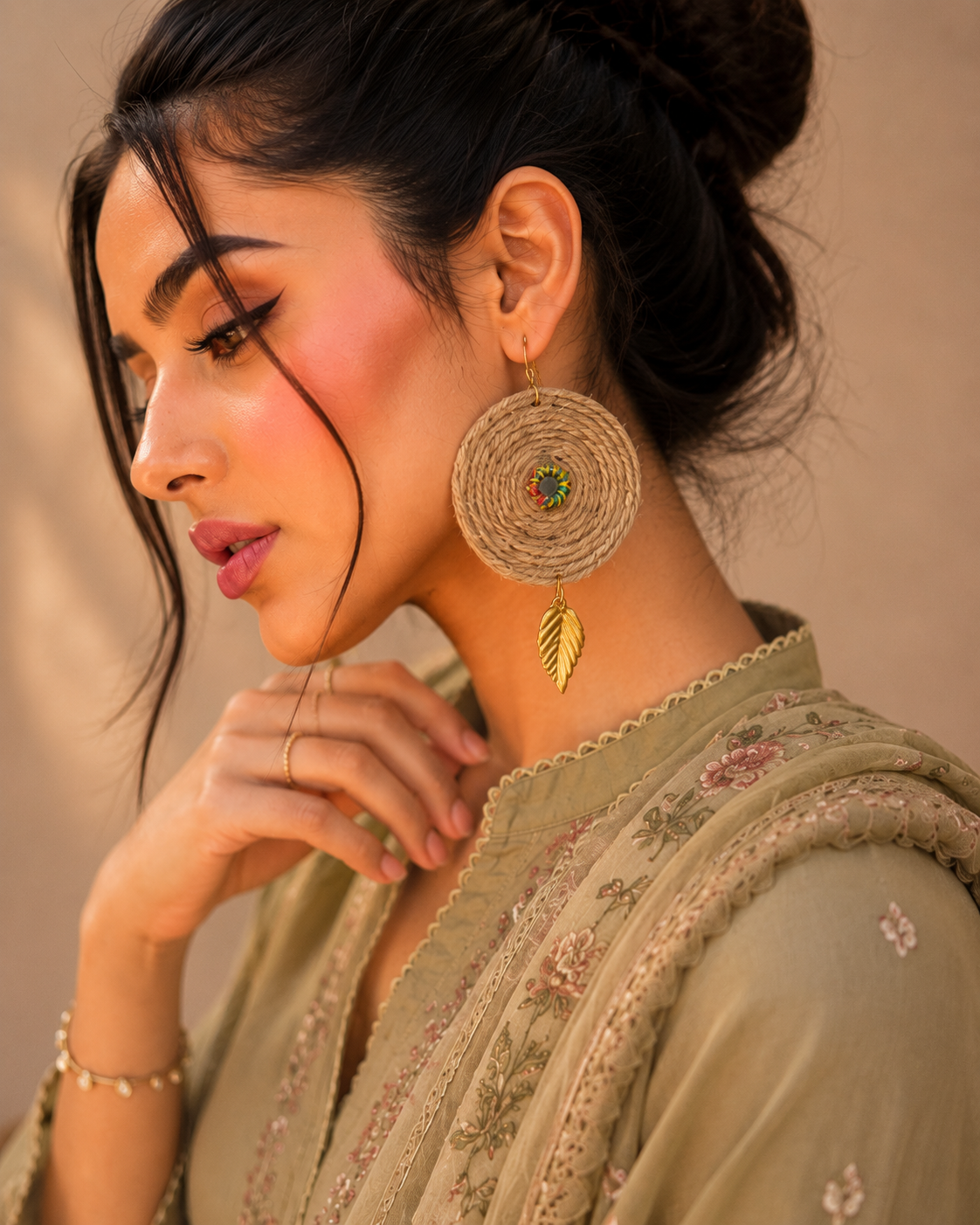 Handmade boho jute earrings with gold leaf charm side view
