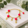 Handmade pink charm bracelet with gold chain and decorative charms for women.